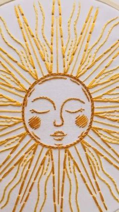 the sun is made up of yellow thread and has eyes drawn on it's face