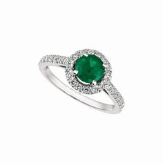 a white gold ring with an oval emerald and diamonds on the band, set in 18k white gold