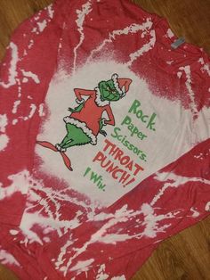 a red and white tie dye shirt with an image of the grinch on it