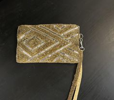 Vintage beaded gold and silver wristlet clutch with an Art Deco geometric design. It features gold beads and silver sequins on both sides of the bag and the handle. The inside is made of a pale yellow satin and is in excellent condition. It was made in India for a company called K C Allah. I did not find any flaws on the outside or inside of the bag. Measurements: 6 3/4" wide by 4" long. Perfect for a night out or any dressy special occasion. Gold Sequined Rectangular Evening Bag, Festive Beaded Gold Clutch, Gold Beaded Rectangular Clutch, Gold Rectangular Beaded Clutch, Rectangular Gold Beaded Clutch, Art Deco Geometric, Yellow Satin, Bag Measurements, Wristlet Clutch