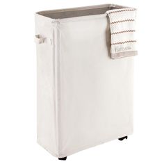 a white laundry hamper sitting on top of a wooden floor