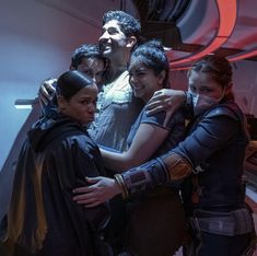 a group of people hugging each other in a room