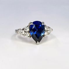 a blue and white diamond ring sitting on top of a table