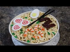 a bowl of noodles with chopsticks and an egg on top