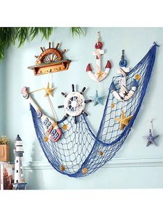 there is a blue net hanging from the wall with various items on it, including an anchor and starfish