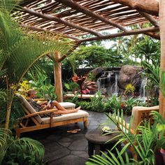 a woman lounging on a chaise lounge surrounded by greenery and tropical plants