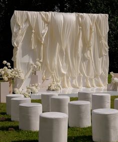 a bunch of white vases sitting in the grass