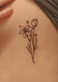 a woman's lower back tattoo with flowers