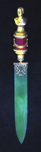 a green glass object with a gold top on it's side and a red stripe around the edge