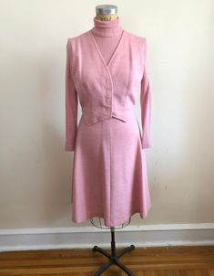 "Long-sleeved, pink knit dress with turtleneck and faux-vest, from the 1970s. Bust measures 19\" (48.5 cm) flat across and waist measures 15\" (38 cm) flat across. The dress is 44\" (112 cm) in length. Acrylic/wool blend." Winter Fitted Pink Dresses, Pink Retro Dress For Work, Retro Pink Dress For Work, 1970s Pink Long Sleeve Dress, Fitted Pink Mod Dress, Pink Fitted Mod Dress, Fitted Retro Pink Outerwear, Vintage Pink Dress For Work, Vintage Pink Dress For Fall