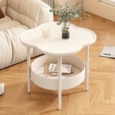 a white coffee table sitting on top of a hard wood floor next to a couch