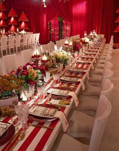 a long table is set up with red and white striped linens for an event