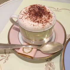 a cappuccino is sitting on a saucer with spoons