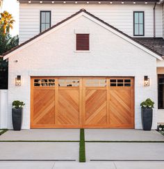 a white house with two wooden garage doors