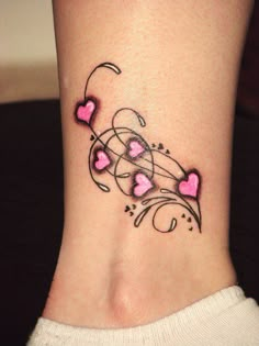 a woman's foot with hearts and swirls on the side, tattoo style