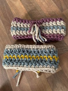 two crocheted items sitting on top of a wooden floor next to each other