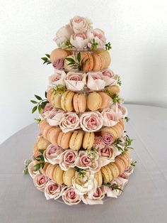 a tiered cake made out of macaroons and roses