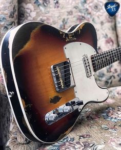 an old guitar sitting on top of a couch