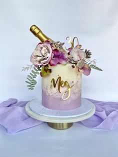 a cake decorated with flowers and a bottle of wine