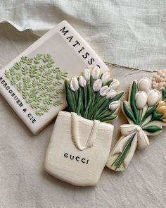 three ceramic flowers are sitting next to each other on a white cloth covered tablecloth