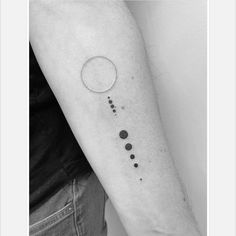 a black and white photo of a person's arm with the phases of planets on it