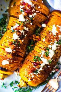 grilled sweet potatoes with feta cheese and herbs on a white plate next to a fork