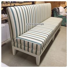 a white and blue striped couch sitting in a room