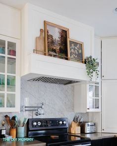 a black stove top oven sitting inside of a kitchen next to white cabinets and counter tops