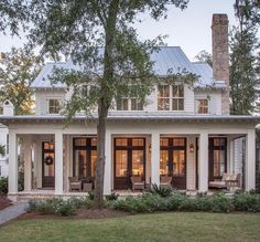 a white house with black doors and windows on the front porch is featured in an instagram