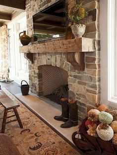 a living room filled with furniture and a fire place in front of a stone fireplace