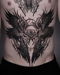 a man with tattoos on his stomach has an eye in the center and two large black wings