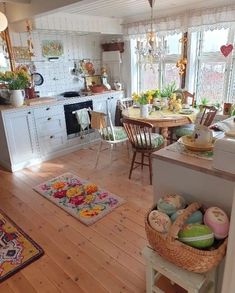 a kitchen filled with lots of furniture next to a table and chairs on top of a hard wood floor