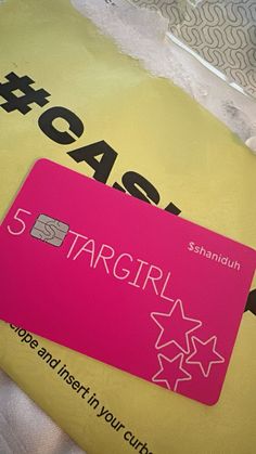 a pink credit card sitting on top of a yellow envelope