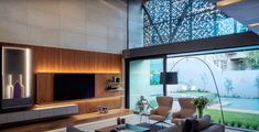 a living room with couches, chairs and a flat screen tv on the wall