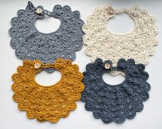 three crocheted bibs are shown on a white surface, one is blue and the other is yellow