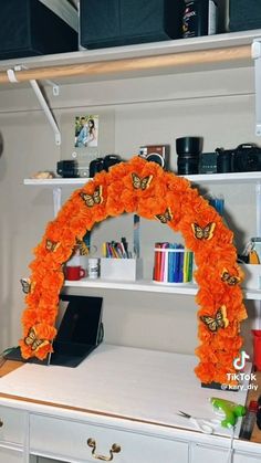 a white desk topped with an orange flower arch