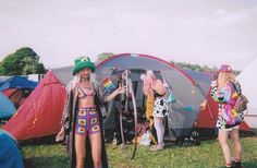 two women standing in front of a tent