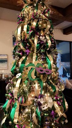 a christmas tree decorated with green and gold ribbons