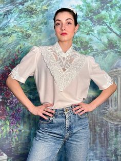 Vintage rare white blouse in embroidery and lace details. Fits size Medium. - Excellent condition - 67% viscose, 33% polyester - One-sided measurements: bust: 49cm, shoulders: 37cm, sleeves: 33cm, length: 68cm - Wash at or below 30oC Chic Floral Embroidery Lace Top, Feminine Cotton Lace Patchwork Top, Feminine Spring Blouse With Lace Sleeves, Chic Cotton Tops With Lace Sleeves, Summer Cotton Lace Top With Lace Sleeves, Summer Wedding Blouse With Lace Sleeves, White Lace Patchwork Cotton Top, Spring Feminine Blouse With Lace Trim, Chic Short Sleeve Blouse With Lace Patchwork