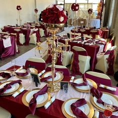 the tables are set with red and white linens, gold place settings and silverware