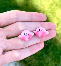 two little pink pigs are sitting in the palm of someone's hand