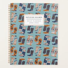 a spiral notebook with blue and orange patterned images on the cover, which reads kalebion holles daily planner