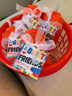 a red basket filled with lots of cards on top of a table