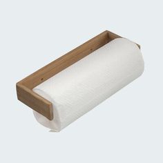 a roll of toilet paper sitting on top of a wooden holder