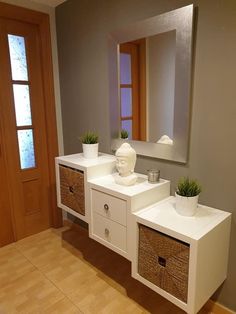 a bathroom vanity with two drawers and a mirror above it, in front of a wooden door