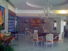 a dining room table with many chairs and a chandelier hanging from the ceiling