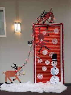 a door decorated with snowmen, reindeers and christmas lights in the corner next to it