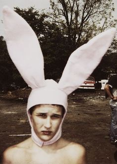 a young man wearing a bunny ears hat