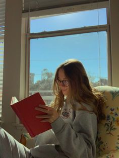 a woman sitting in a chair reading a book