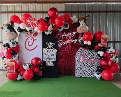 the balloon arch is decorated with red, black and white balloons